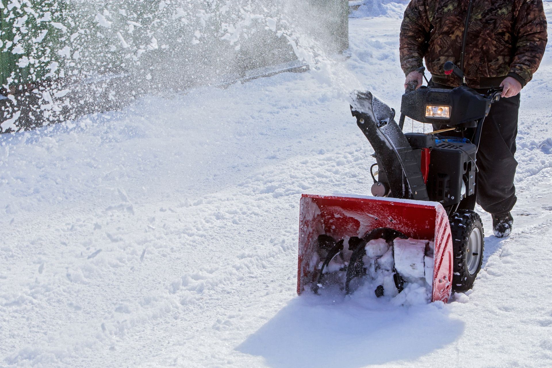 man cleans snow with a snow-removing machine